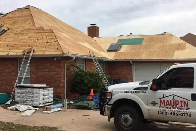 maupin roofing service truck and maupin roofers during a roofing project