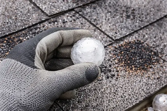 a person on a rooftop holds a large piece of ice