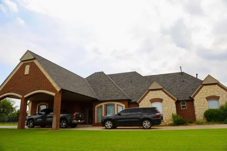 Brick and stone home with a new dark architectural shingle roof by Maupin Roofing & Construction