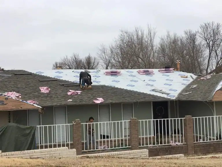 Roof decking covered in underlayment with shingle bundles staged