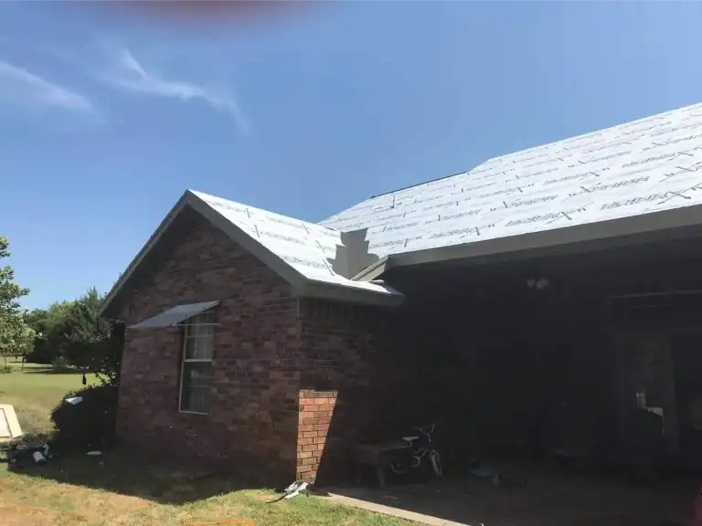 Underlayment installed over roof decking on a brick home