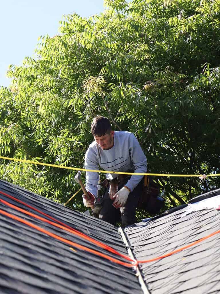 Roofer installing ridge shingles, a Maupin Roofing & Construction job